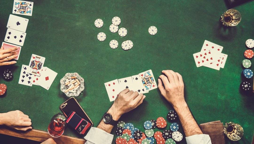 A view from above a poker table with friends playing a poker game together.