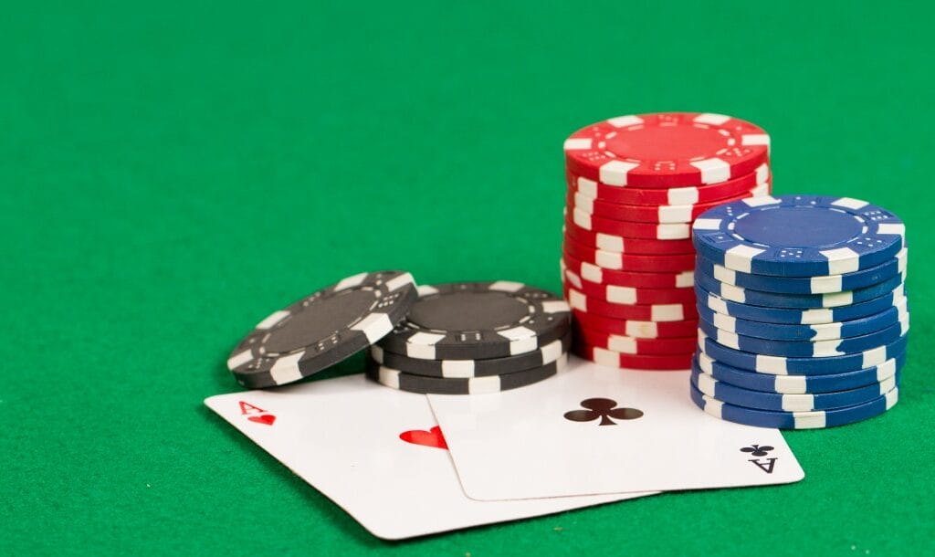Playing cards and casino chips on a green table.