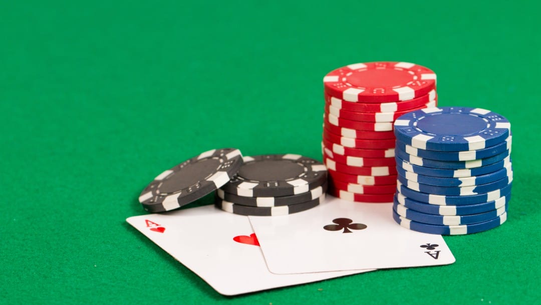 Playing cards and casino chips on a green table.