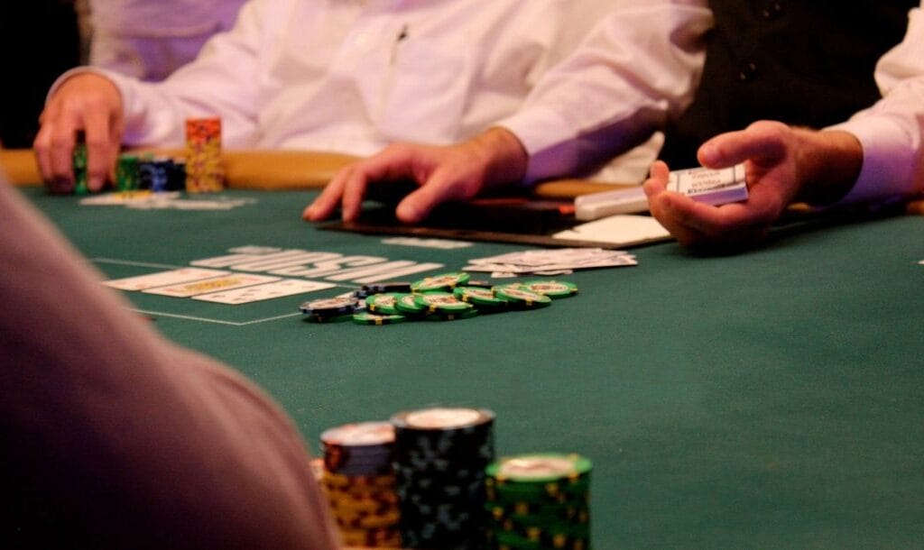 People sitting around a poker table, engaging in a game of poker.