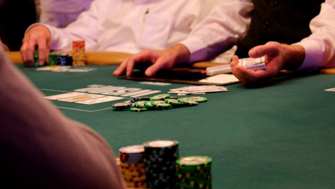 People sitting around a poker table, engaging in a game of poker.