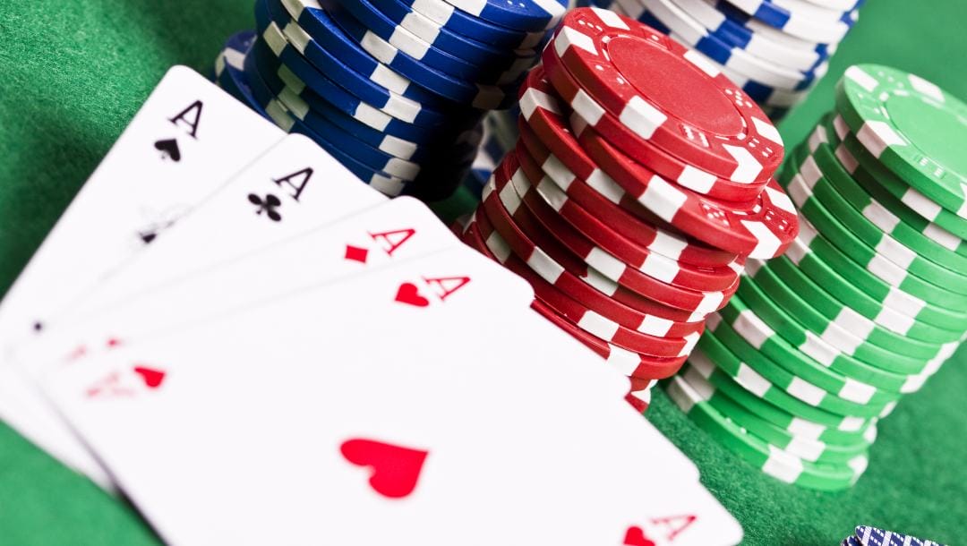 Poker Aces and casino chips on a green felt table.