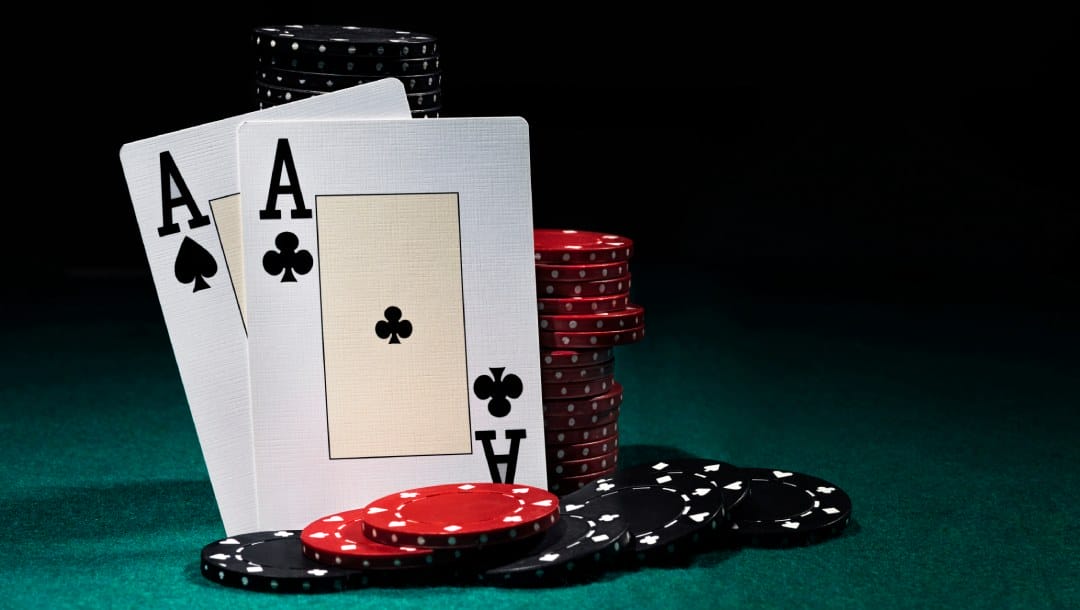 Ace cards and casino chips on a green felt table.