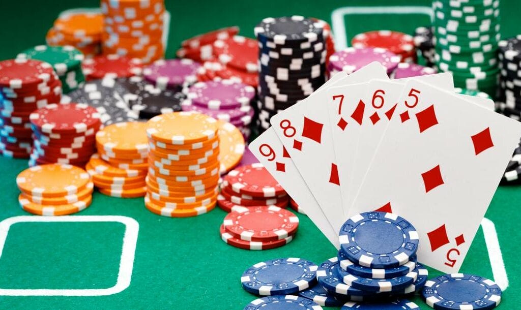 Playing cards and casino chips on a green felt table.