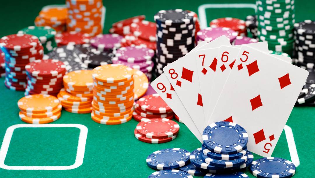 Playing cards and casino chips on a green felt table.