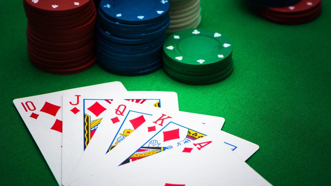 Poker chips and playing cards on a green felt table