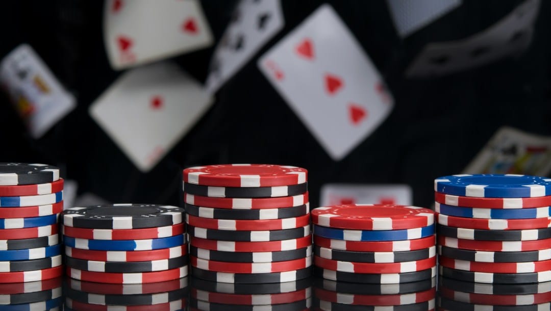 Casino chips with playing cards in the background.