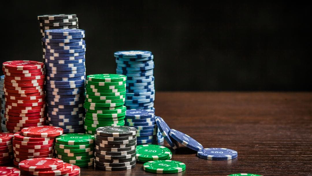 Poker chips stacked on a wooden table surface