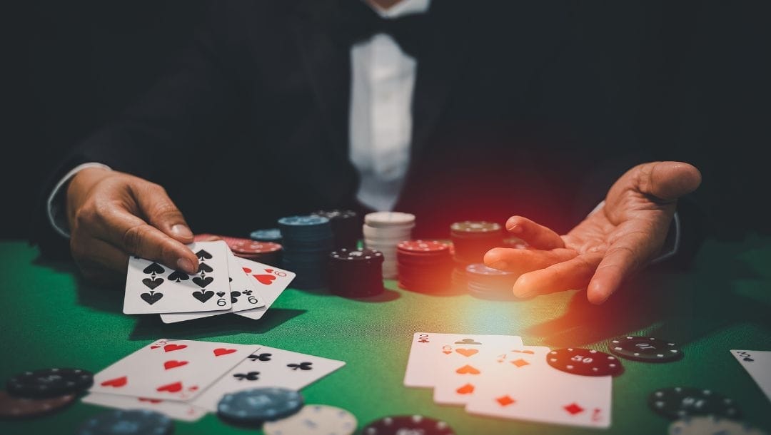 A casino dealer seated at a poker table, dealing cards to players, with casino chips arranged on the table.
