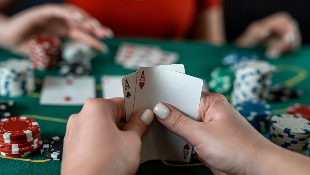 Close-up of a poker player’s winning hand — a pair of aces.