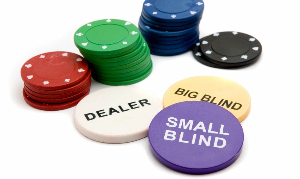 The three poker buttons for the dealer, big blind, and small blind, next to several stacks of poker chips.