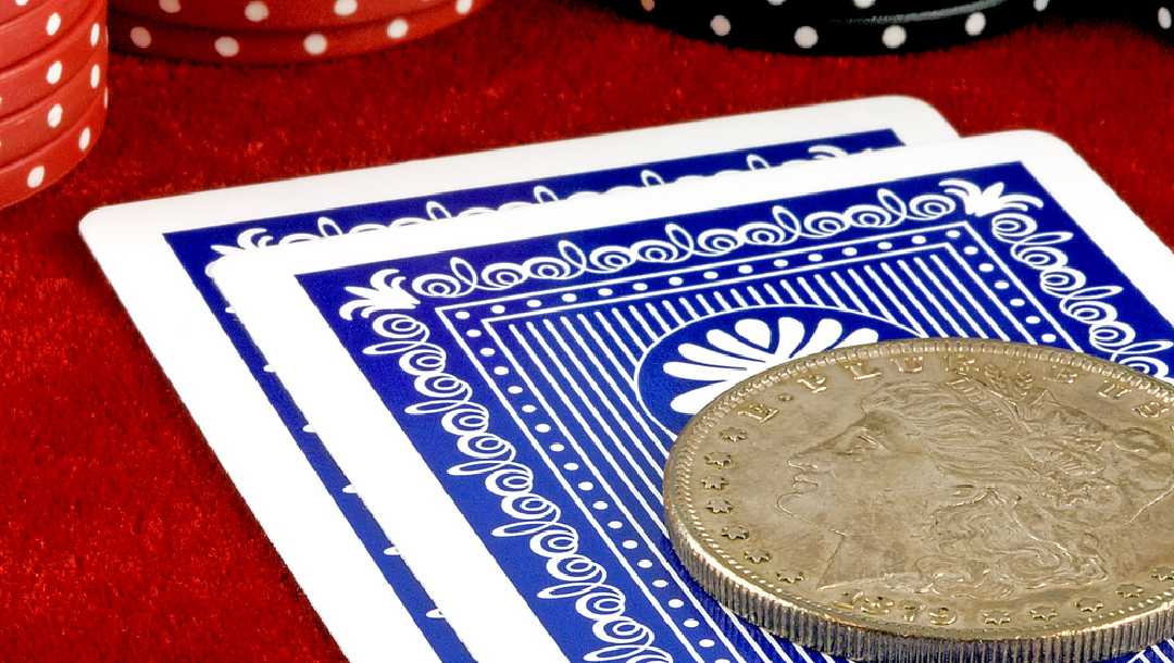 Playing cards with a coin on top of them.