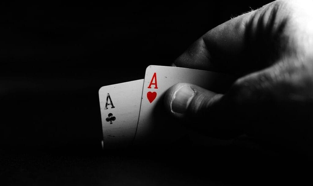 a close up of a person lifting a pair of ace playing cards