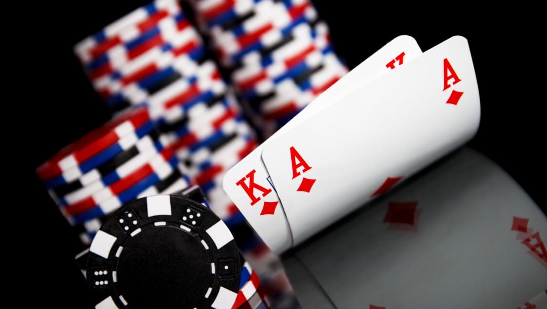 Playing cards with poker chips against a black background.