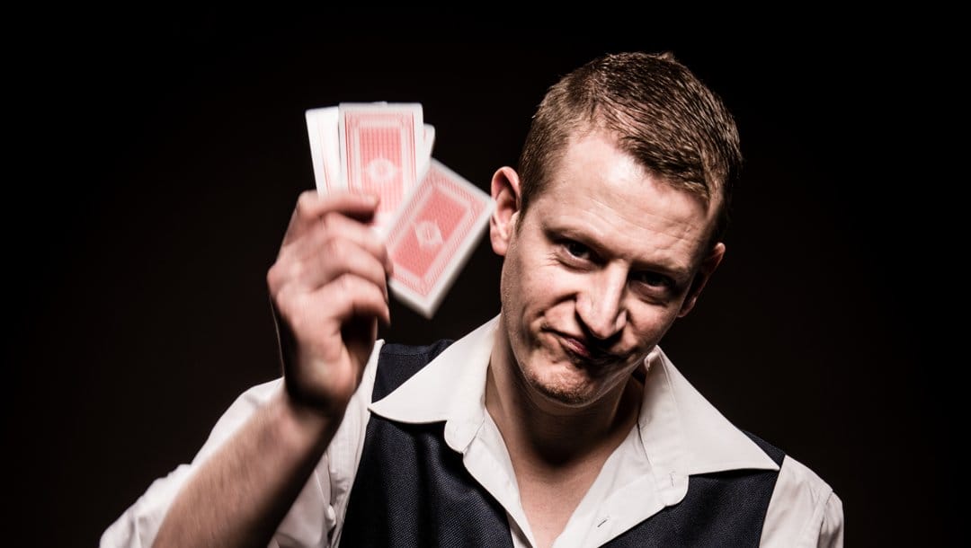An unhappy man about to slap his hand of cards down.