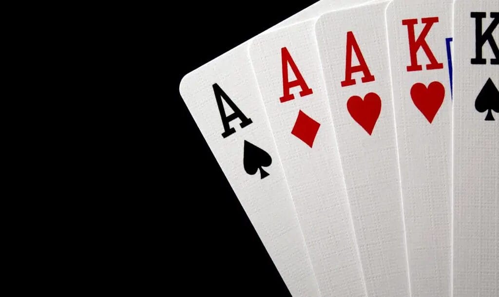 Five playing cards in the righthand corner against a black background.