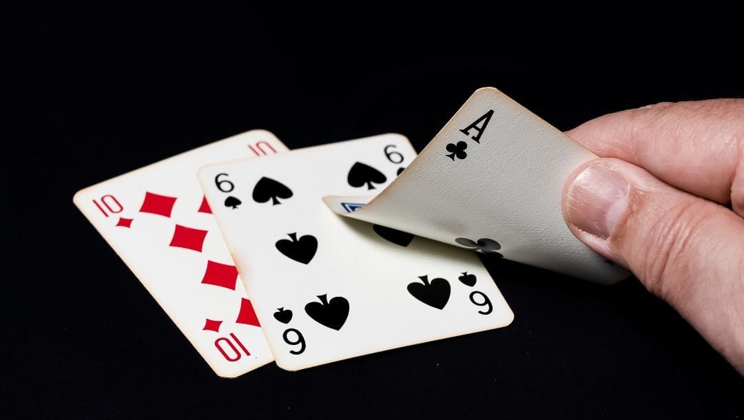 three off-suit cards - a ten of diamonds, six of spades and ace of clubs - on a black surface