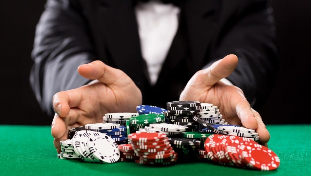 Hands pushing forward stacks of poker chips