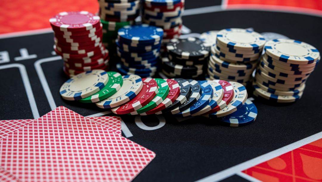 poker chips and two playing cards face down on a poker table