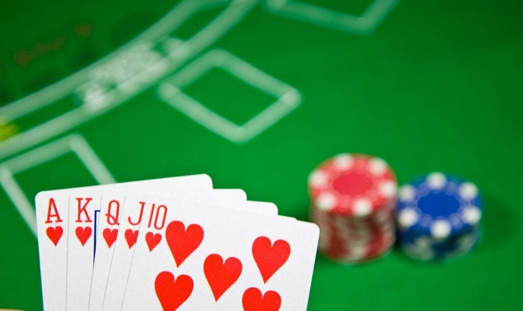 A royal flush with a poker table in the background