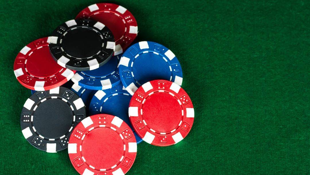 top view of a pile of poker chips on a green felt poker surface