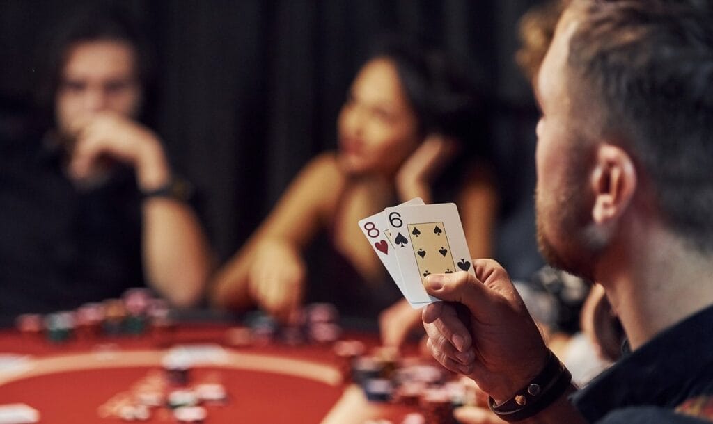 Group of young people playing poker in a casino together