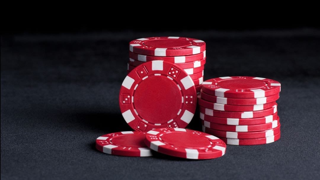 Two stacks of red poker chips on a table.