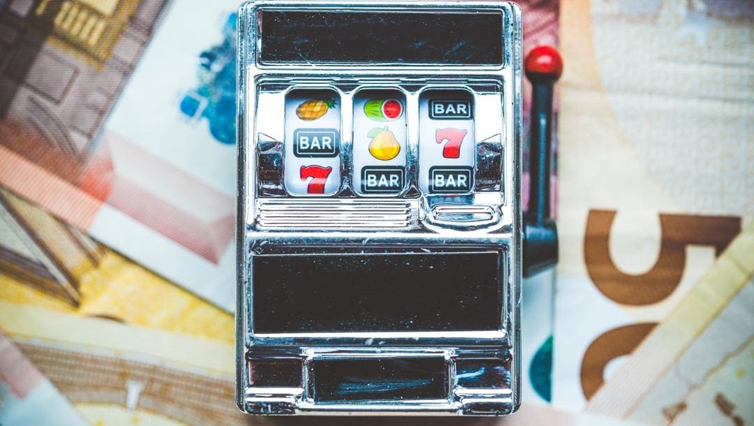 Gambling slot machine in close-up view on money background
