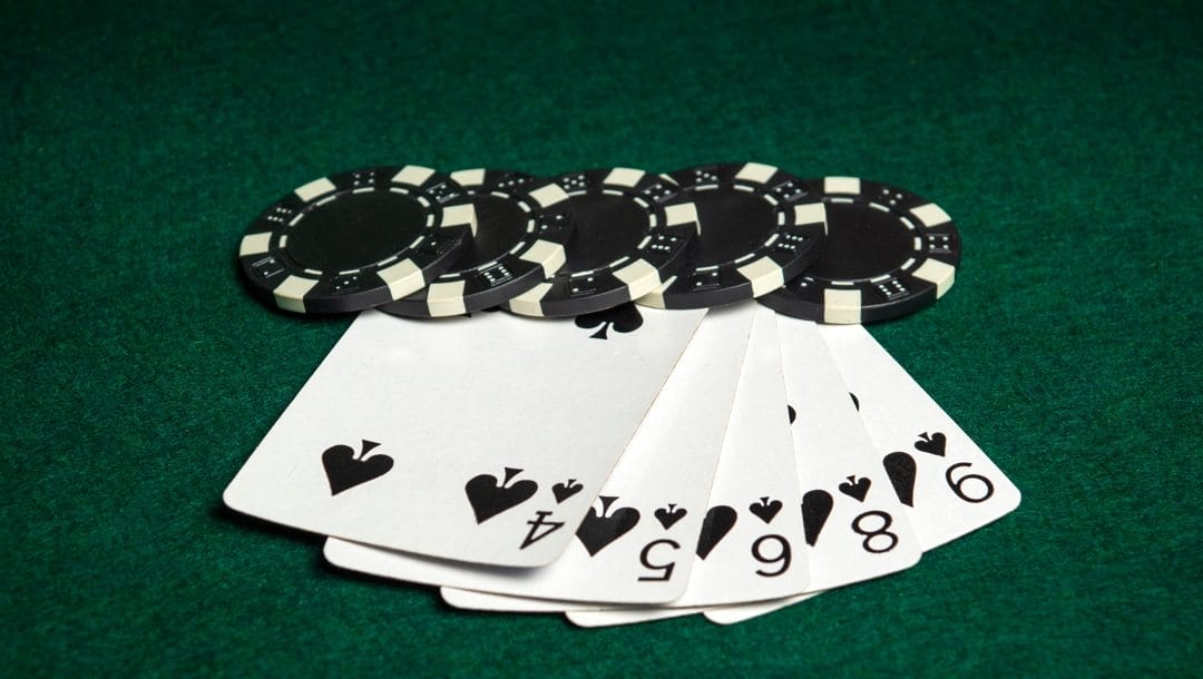 Stud poker game with straight combination, chips, and cards on a green poker table