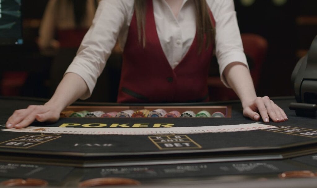 A croupier fanning out a deck of cards on a poker table.