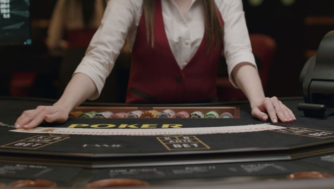 A croupier fanning out a deck of cards on a poker table.