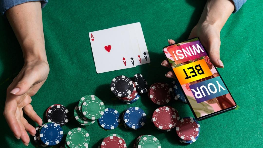 Inscription “your bet wins” on a smartphone on the poker table