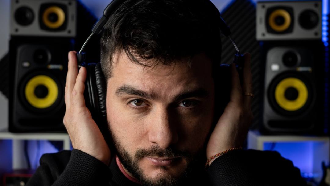 A man holding his headphone on his ears listening to music