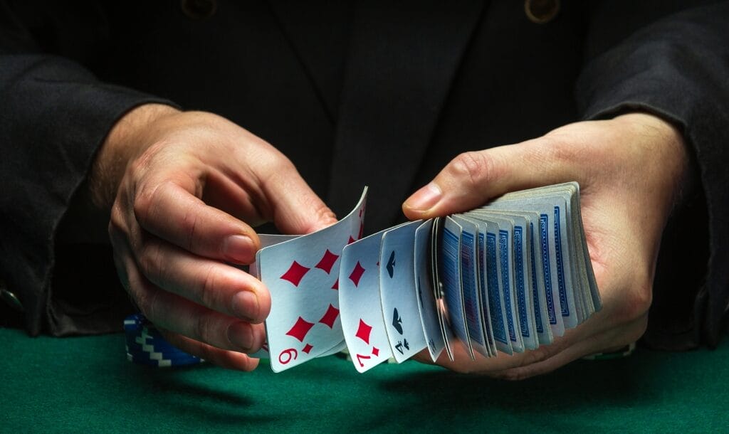 Two hands shuffle a deck of cards