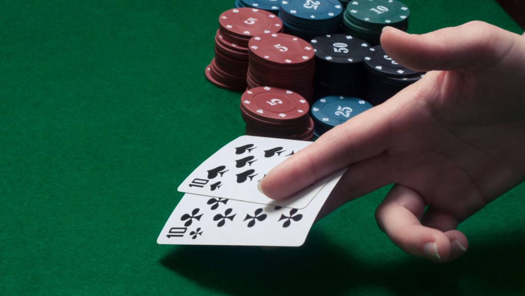 A poker player puts a hand with two tens down on the table