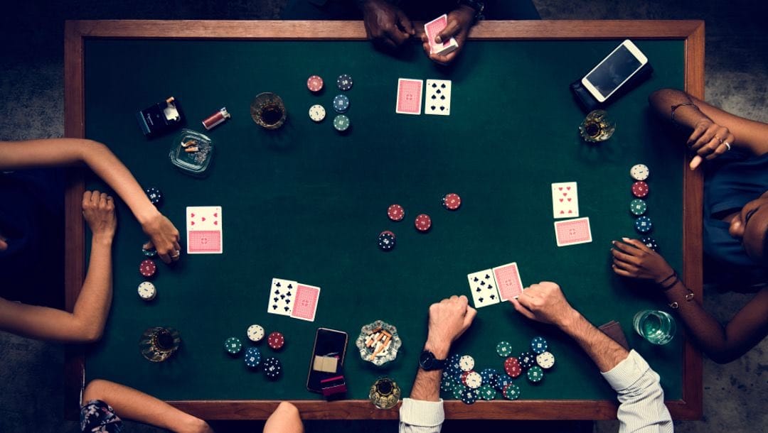 Aerial view of people playing poker at a casino table.