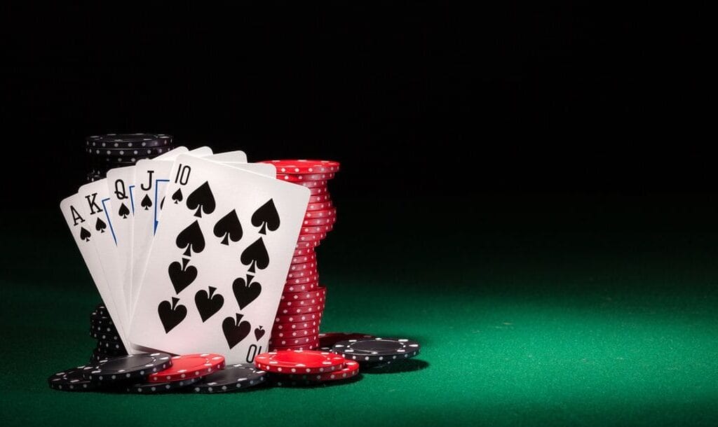 Playing cards featuring a royal flush against stacks of casino chips.