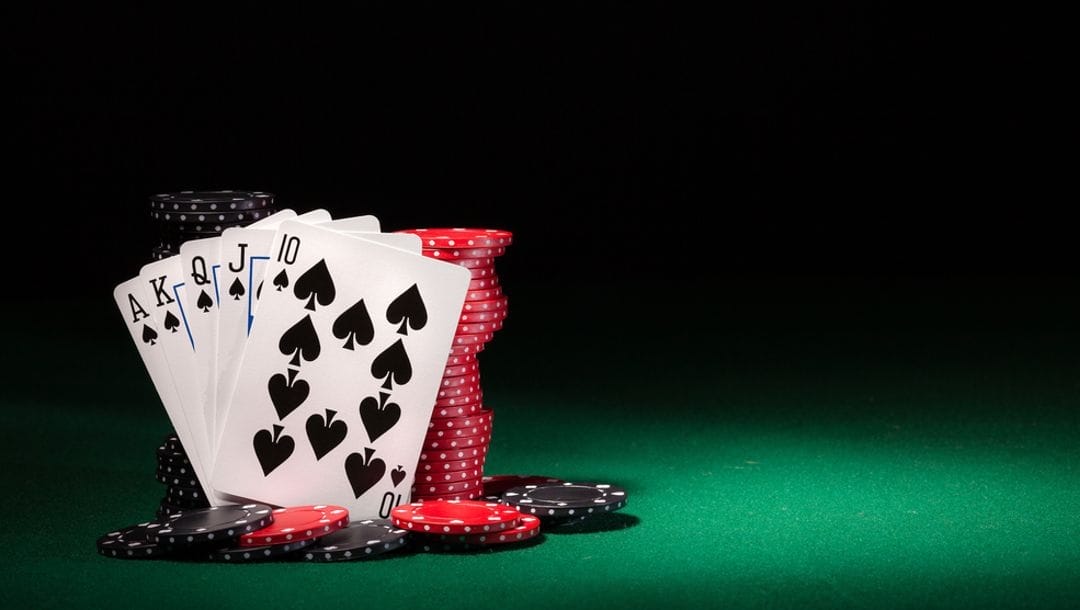 Playing cards featuring a royal flush against stacks of casino chips.