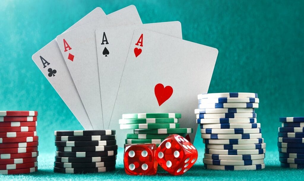 Four aces behind stacks of poker chips and two dice.