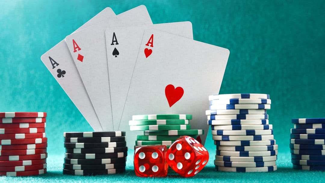 Four aces behind stacks of poker chips and two dice.