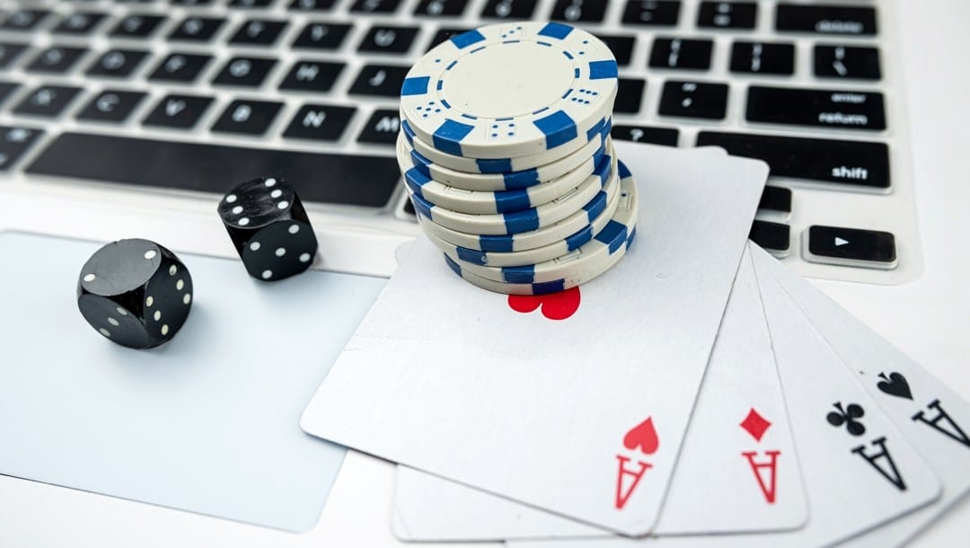 Laptop two black dice playing card and casino chips