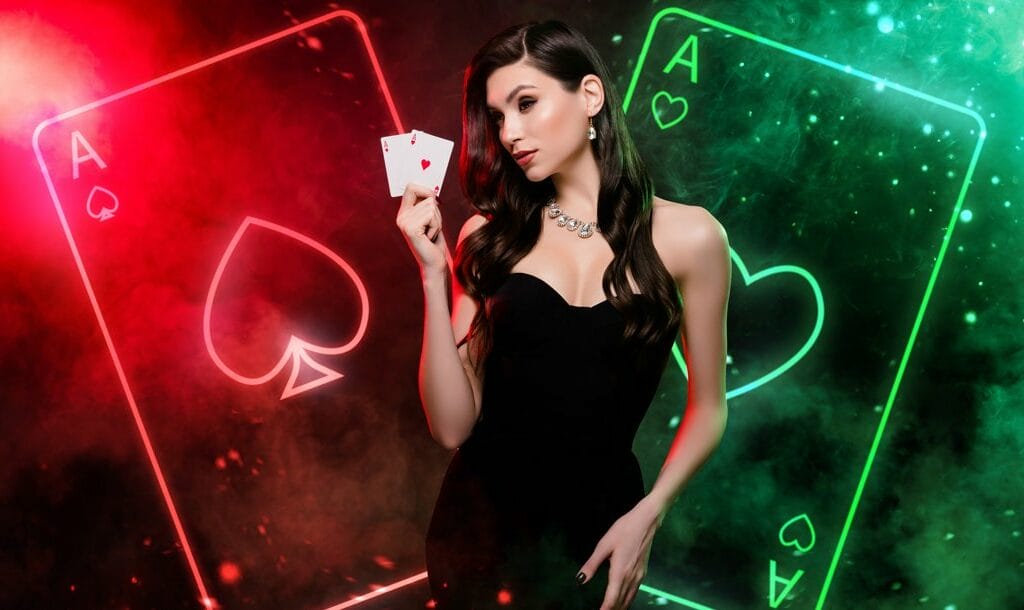 A person wearing a black dress and holding up two aces. Behind them is a neon red and green outline of two aces.