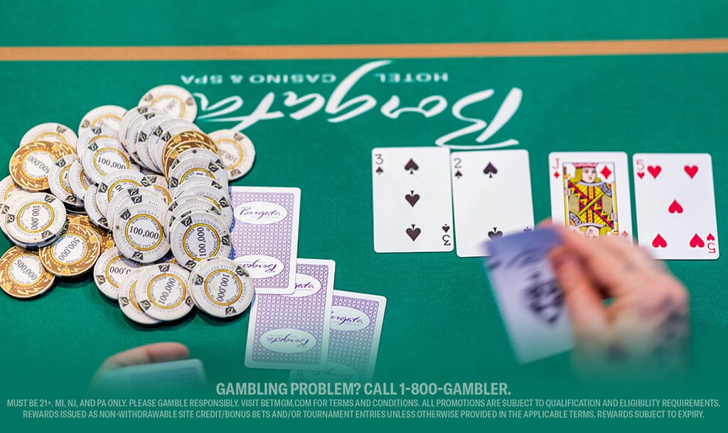 A poker table with a green felt surface, stacked with numerous gold and white chips. Nearby, three playing cards are visible: 4 of spades, 2 of spades, and King of hearts. A blurred hand holds more cards in the foreground.