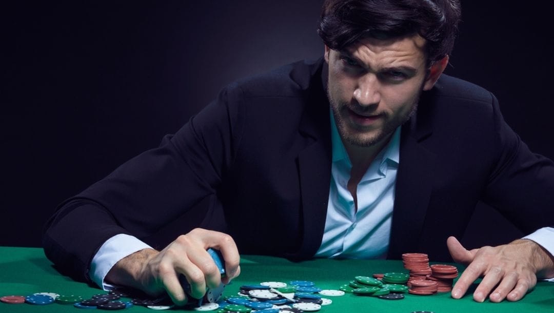A person wearing a suit playing at a poker table.