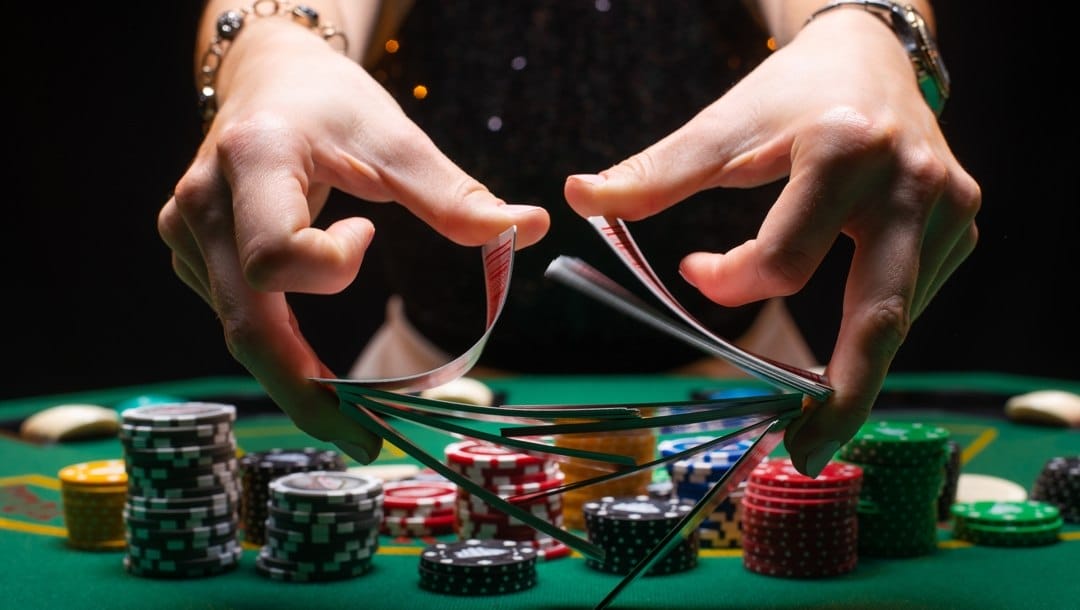 Croupier shuffles poker cards in a casino.