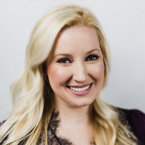 A smiling woman with blonde hair against a white background.