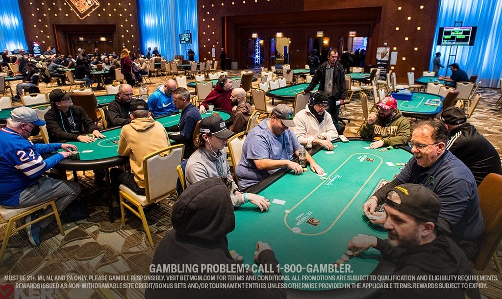 A lively poker tournament with players seated at green felt tables in a dimly lit casino. The atmosphere is focused and intense.