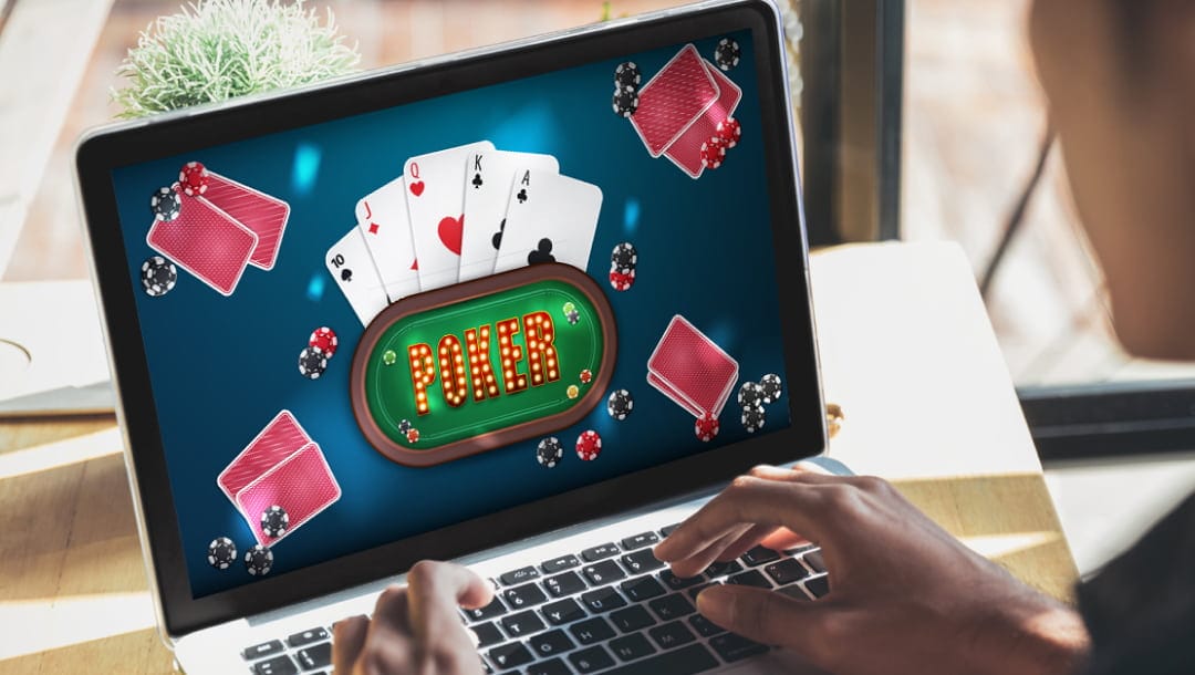 A person sitting at a table, playing an online poker game on a laptop.