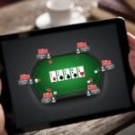 Hands holding a tablet device with an online poker game on the screen.