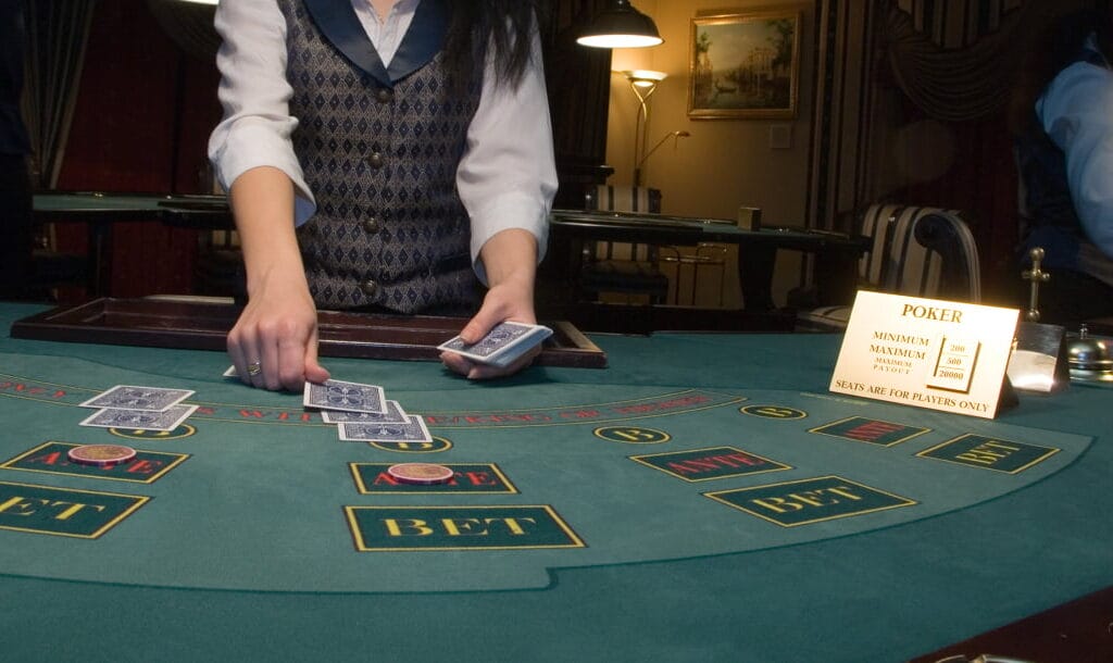 A dealer dealing out cards at a poker table.